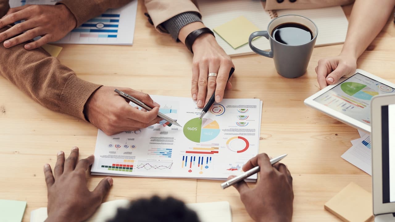 Advisors reviewing analytics and charts around a strategy table