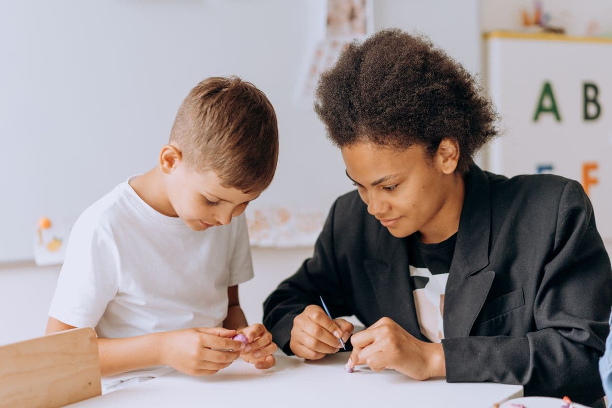 Mentor guiding a young student through a learning activity